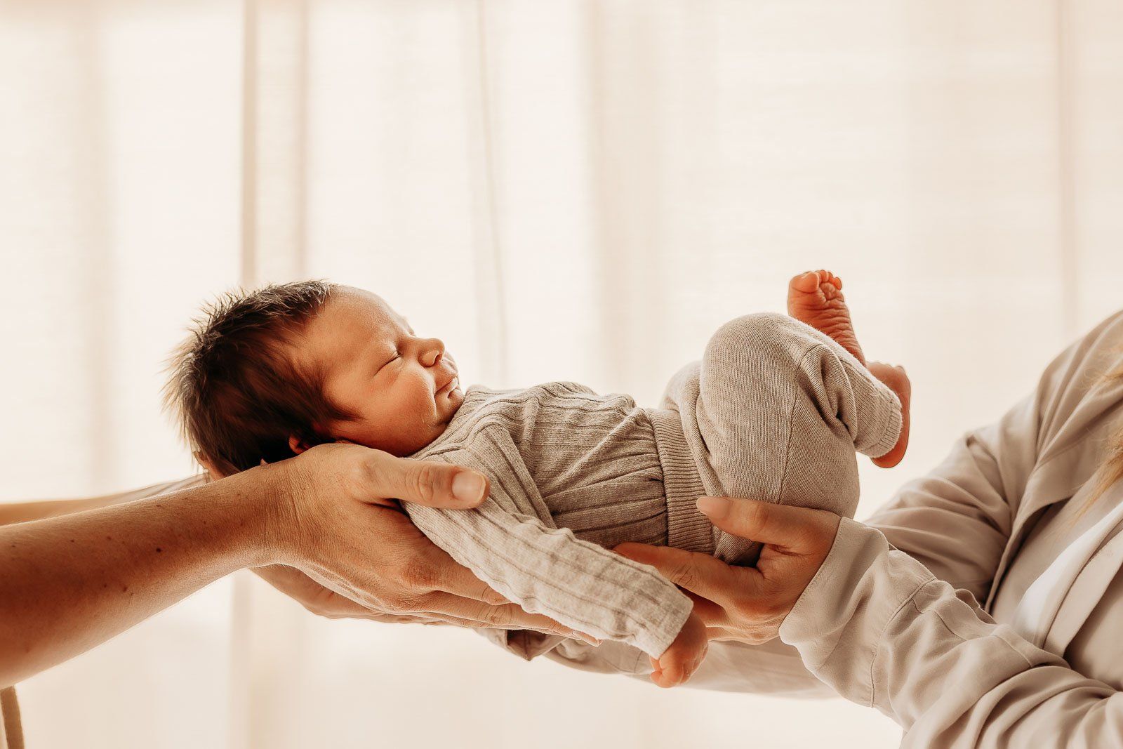 Großes Geschwisterkind betrachtet das neue Baby mit neugierigen Augen